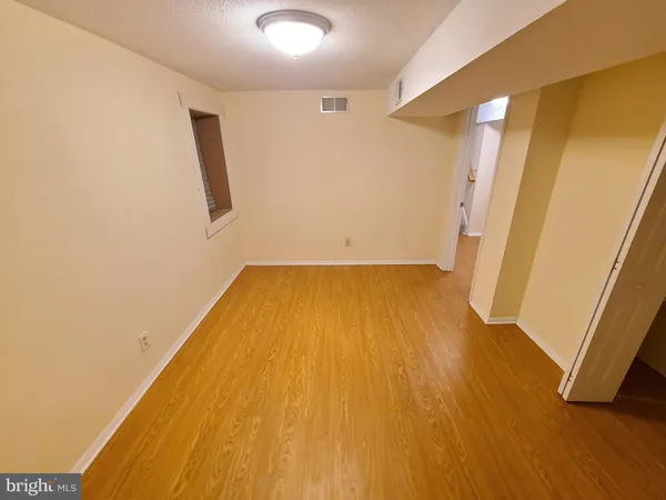 a view of a big room with wooden floor and entrance