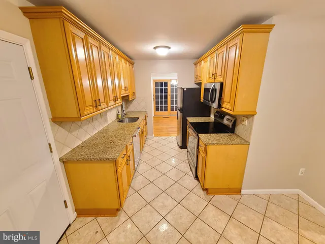a view of kitchen with furniture and refrigerator