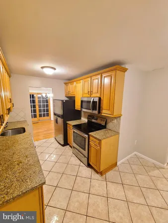 a living room with couches a flat screen tv and kitchen view