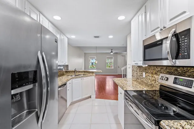 a large kitchen with stainless steel appliances granite countertop a stove and a sink