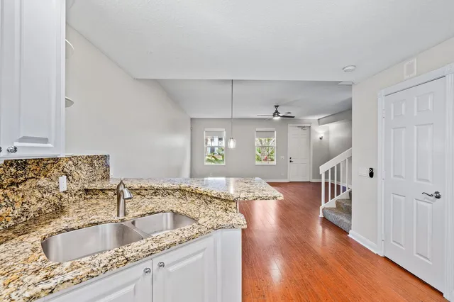 a kitchen with granite countertop a sink and a wooden floor