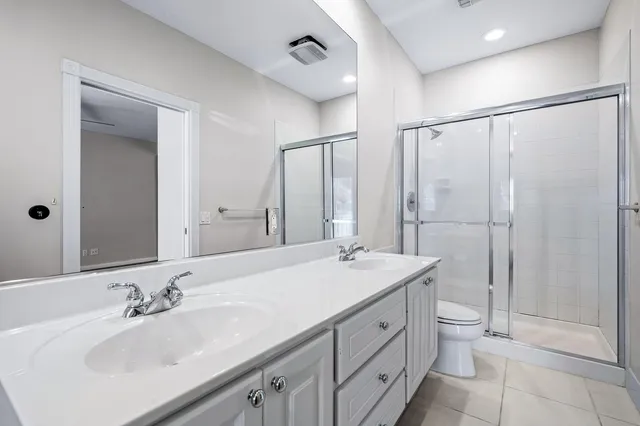 a bathroom with a double vanity sink mirror and shower