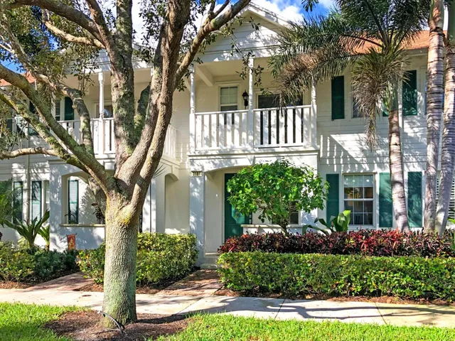 a view of a house with a yard and potted plants