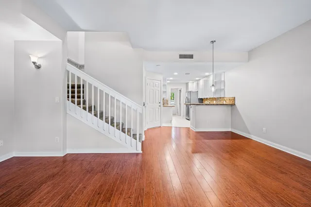 a view of empty room with wooden floor