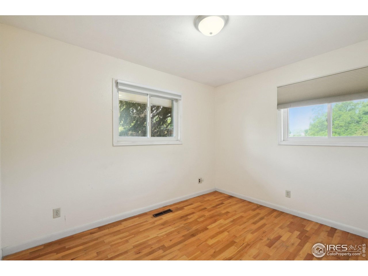 2001 Evergreen Drive Fort Collins, CO 80521 - Photo 14 of 39 an empty room with wooden floor and windows