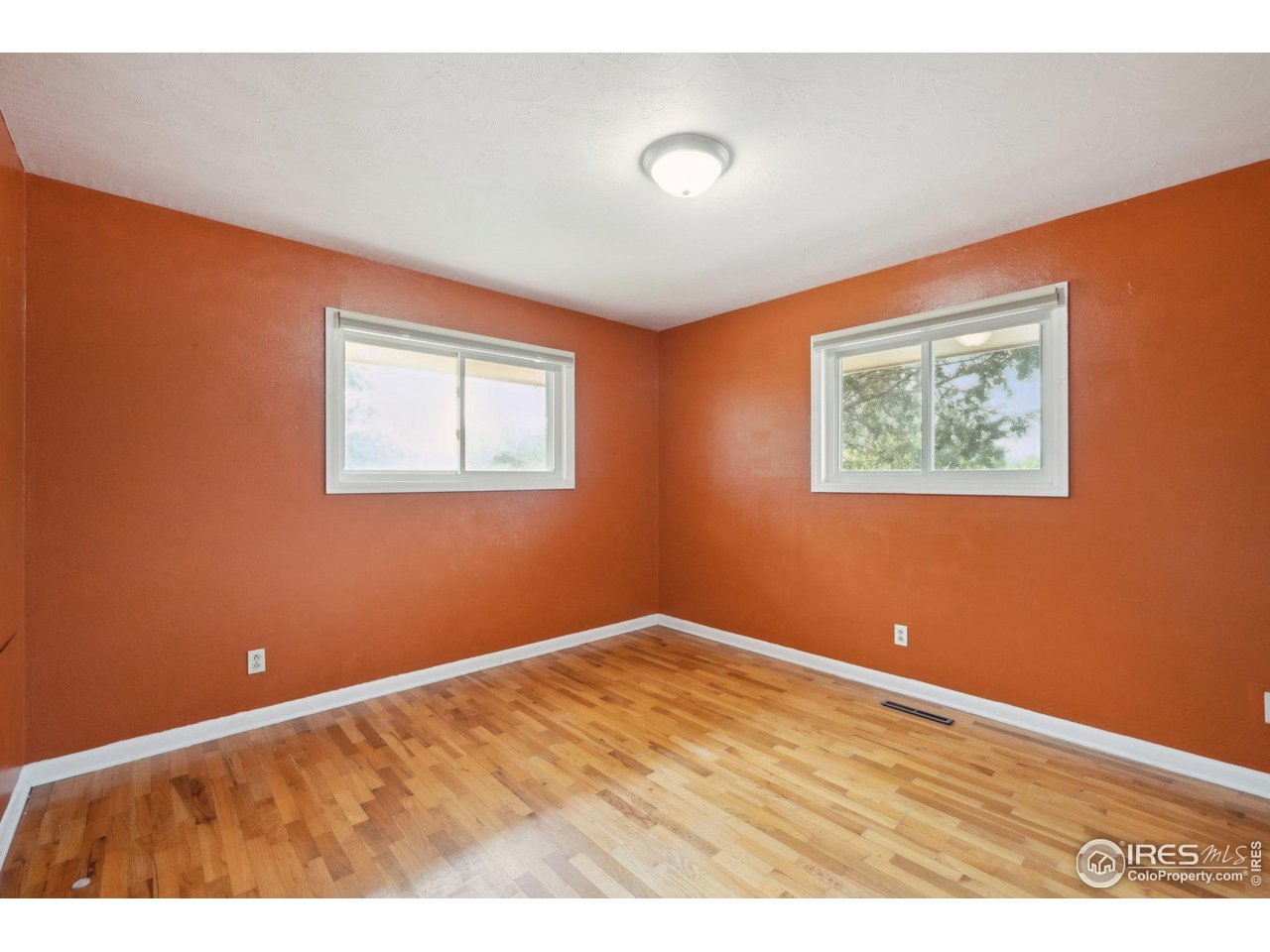2001 Evergreen Drive Fort Collins, CO 80521 - Photo 15 of 39 an empty room with wooden floor and windows