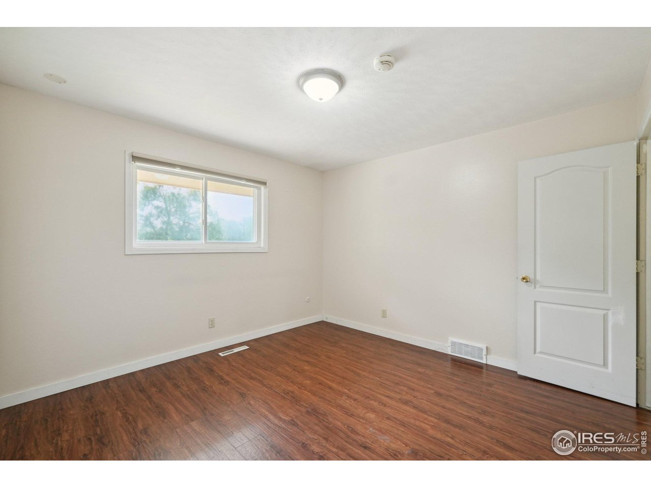 2001 Evergreen Drive Fort Collins, CO 80521 - Photo 17 of 39 a view of an empty room with wooden floor and a window