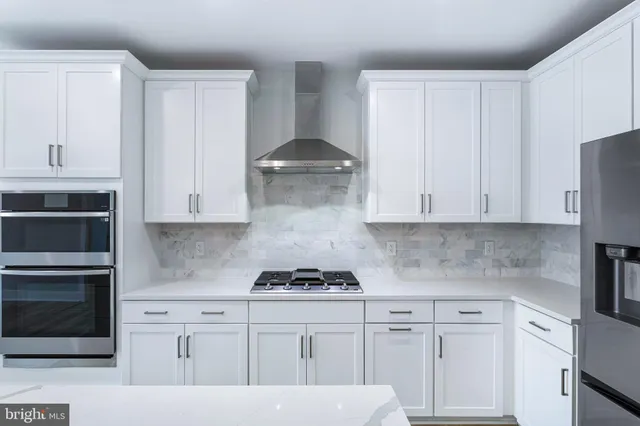 a kitchen with white cabinets and a stove