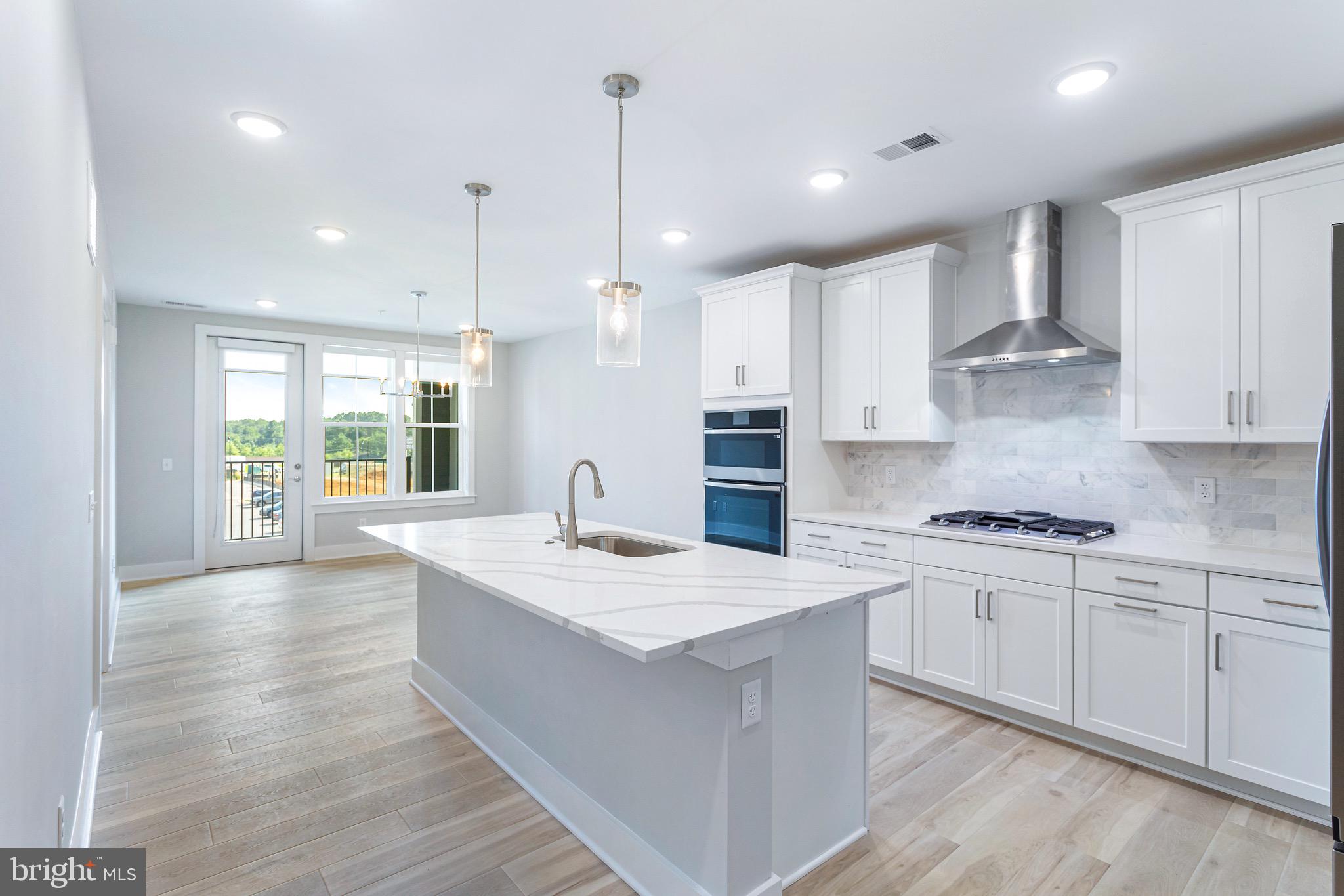 76 Old Mill Bottom Road North, Unit 308 Annapolis, MD 21409 - Photo 18 of 38 a kitchen with stainless steel appliances granite countertop a sink a stove a refrigerator and island with wooden floor