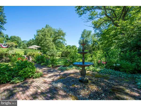 a front view of a house with a yard and fountain