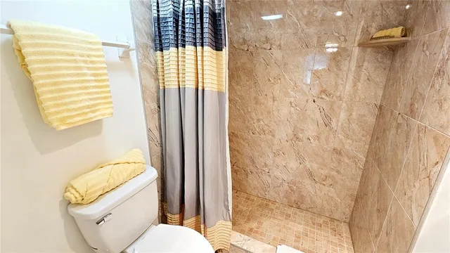 a bathroom with a toilet and a shower