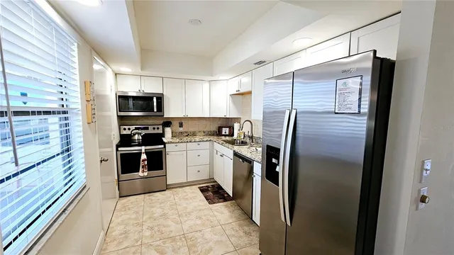 a kitchen with a refrigerator and a sink