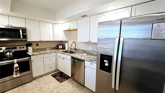 a kitchen with stainless steel appliances granite countertop a stove a sink and a microwave