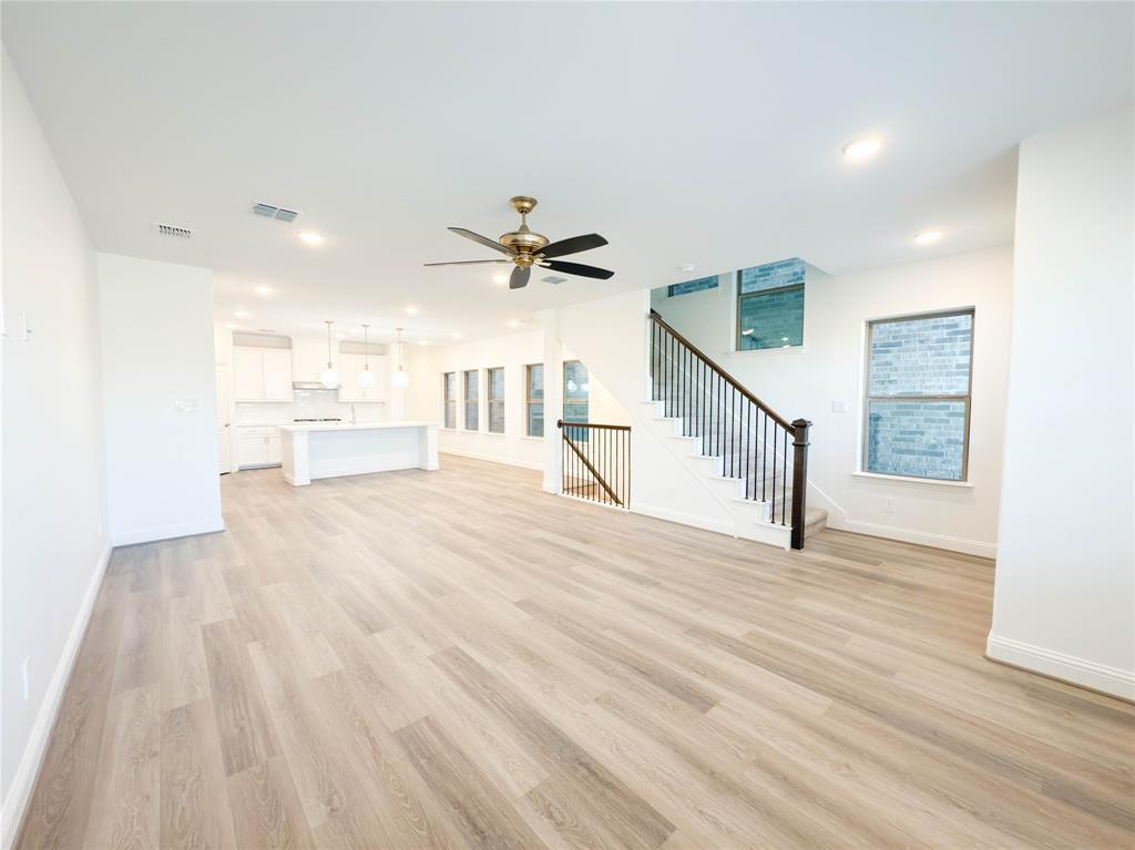 114 Settlers Way Euless, TX 76040 - Photo 11 of 38 a view of an empty room with wooden floor and a ceiling fan