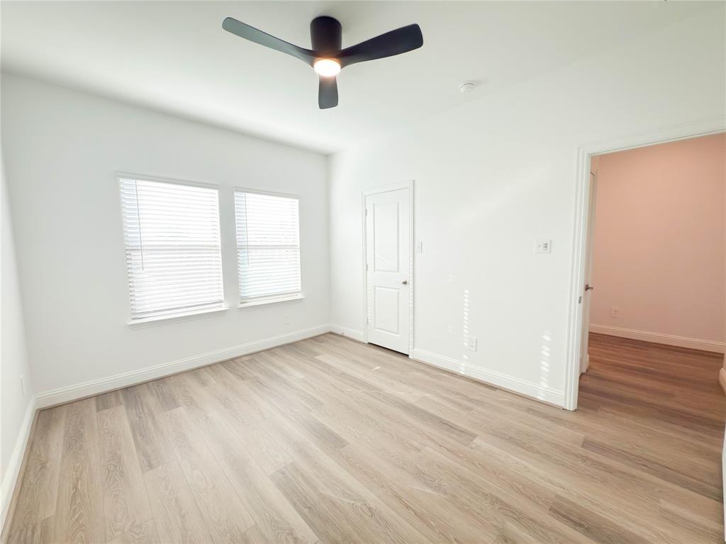 114 Settlers Way Euless, TX 76040 - Photo 13 of 38 an empty room with wooden floor ceiling fan and windows