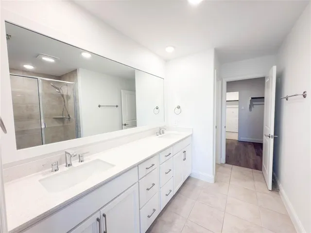 a spacious bathroom with a double vanity sink shower and a mirror