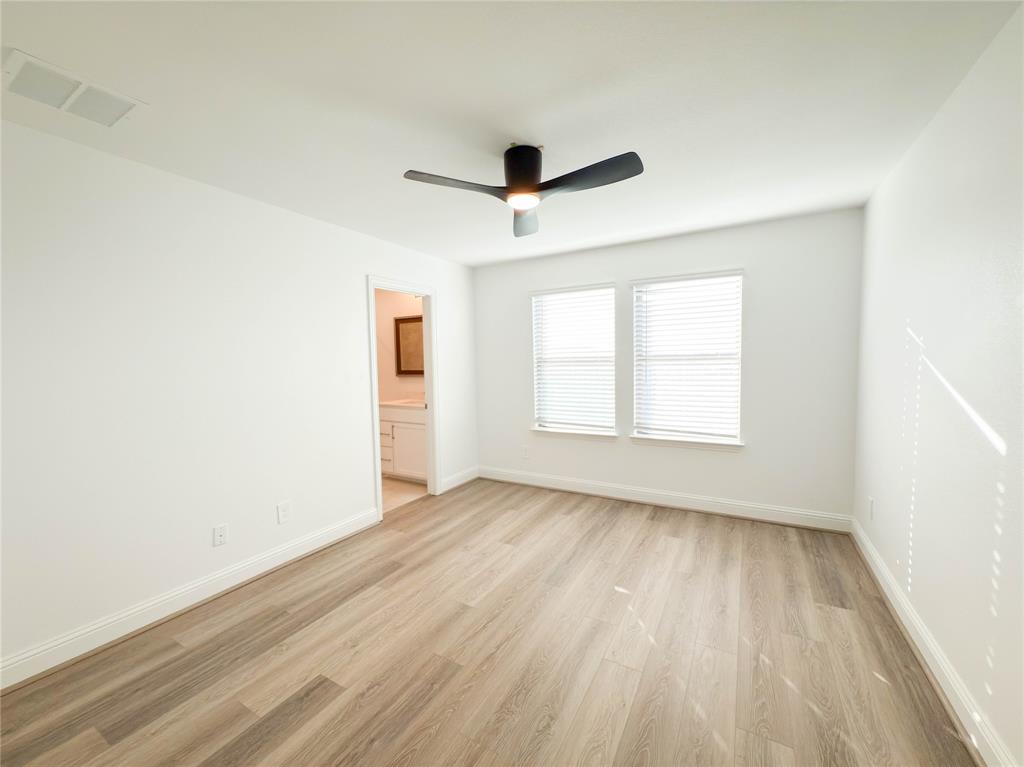 114 Settlers Way Euless, TX 76040 - Photo 27 of 38 an empty room with wooden floor ceiling fan and windows