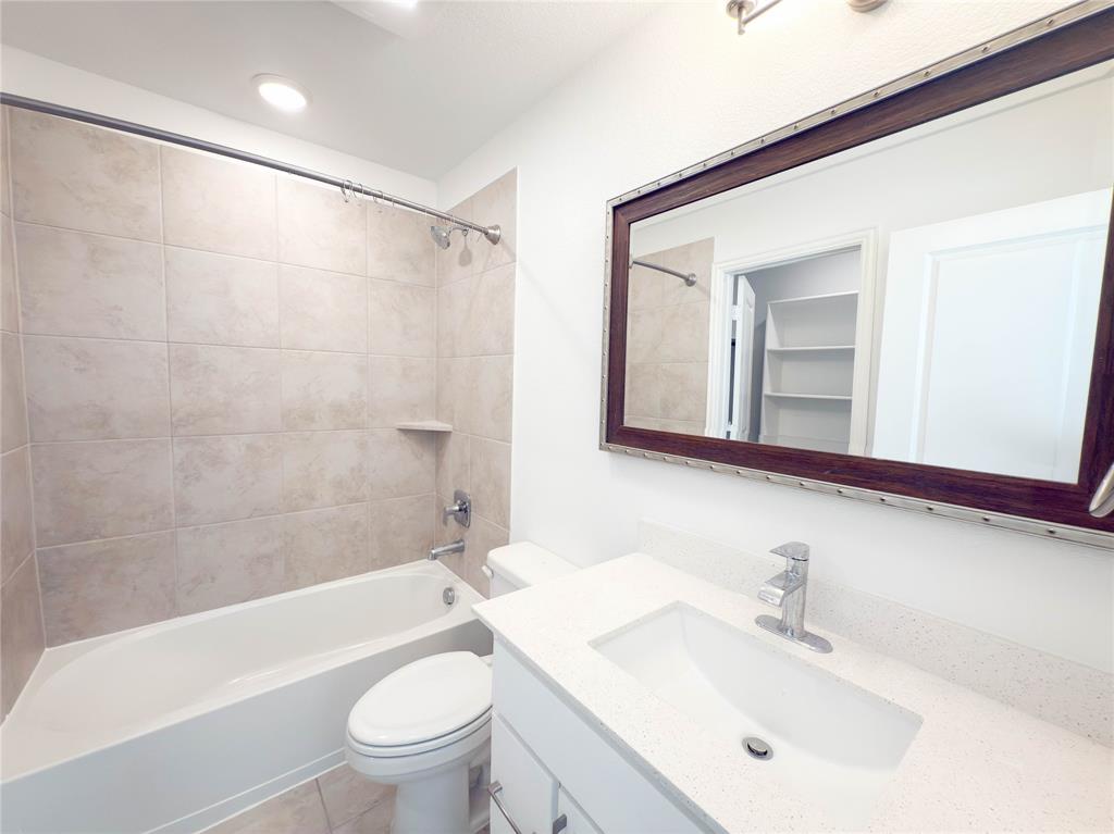 114 Settlers Way Euless, TX 76040 - Photo 29 of 38 a bathroom with a sink a toilet and a large mirror