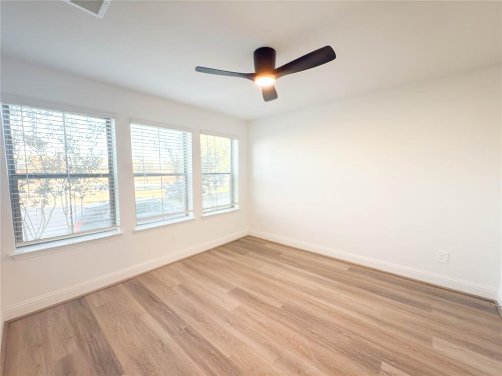 114 Settlers Way Euless, TX 76040 - Photo 31 of 38 an empty room with wooden floor fan and windows