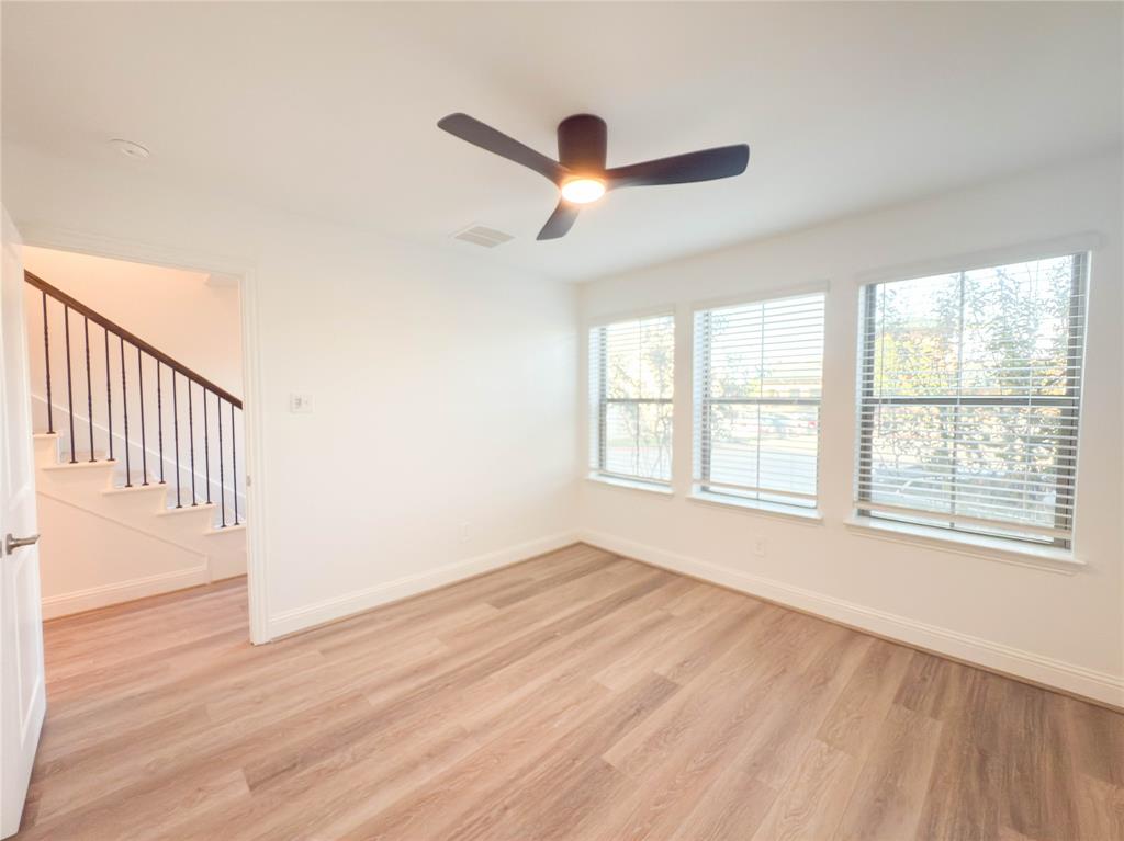 114 Settlers Way Euless, TX 76040 - Photo 32 of 38 an empty room with wooden floor fan and windows
