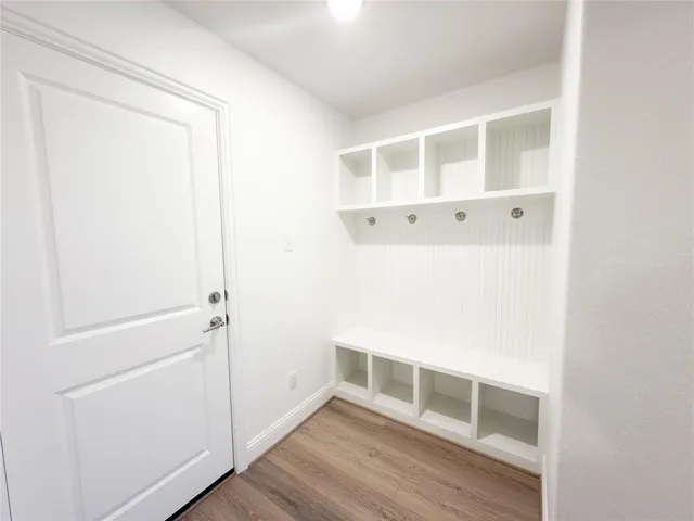 a view of an empty room with wooden floor and closet