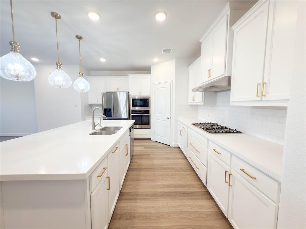 114 Settlers Way Euless, TX 76040 - Photo 6 of 38 a large kitchen with kitchen island a stove a sink a center island and wooden floor