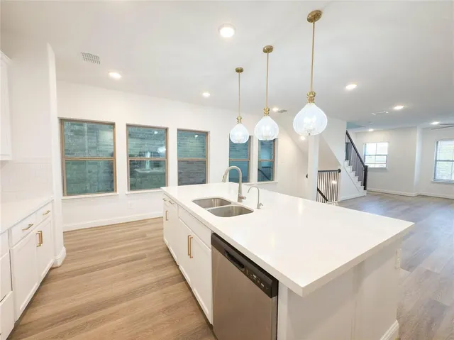 a large white kitchen with a large island