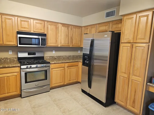 a kitchen with stainless steel appliances granite countertop a stove a sink and a microwave