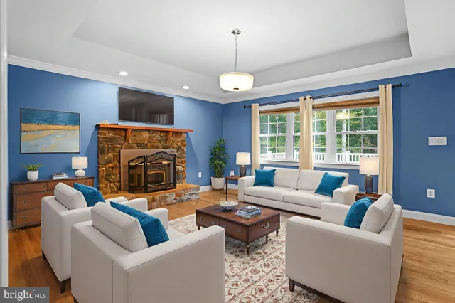 a living room with furniture a fireplace and a large window