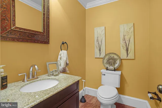 a bathroom with a granite countertop toilet sink and mirror