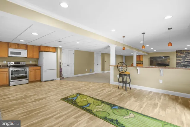 a living room with stainless steel appliances kitchen island granite countertop furniture wooden floor and a view of kitchen