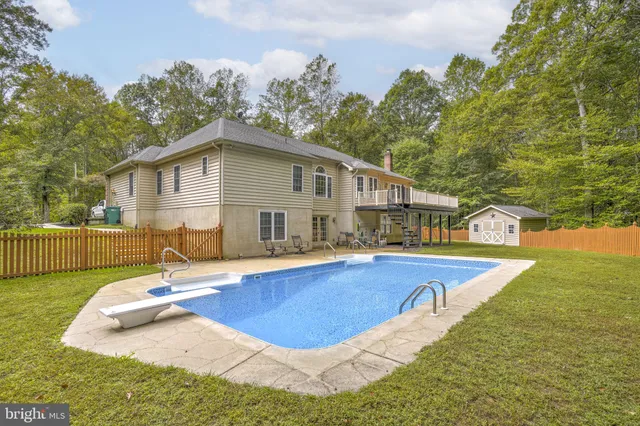 a view of a house with pool and chairs