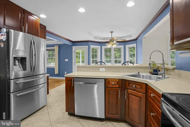 a kitchen with stainless steel appliances granite countertop a sink and a refrigerator