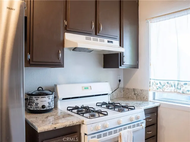 a kitchen with kitchen island a counter top a stove and a sink