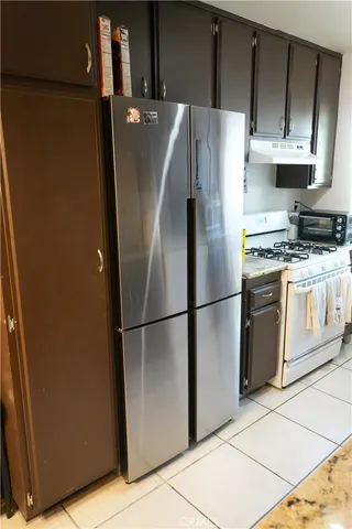 a white refrigerator freezer and a stove sitting inside of a kitchen