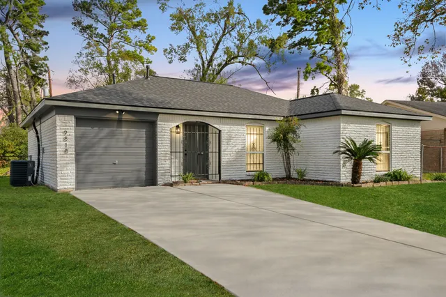 a front view of a house with a garden and plants