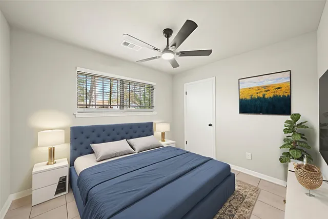 a bedroom with a large bed and a chandelier