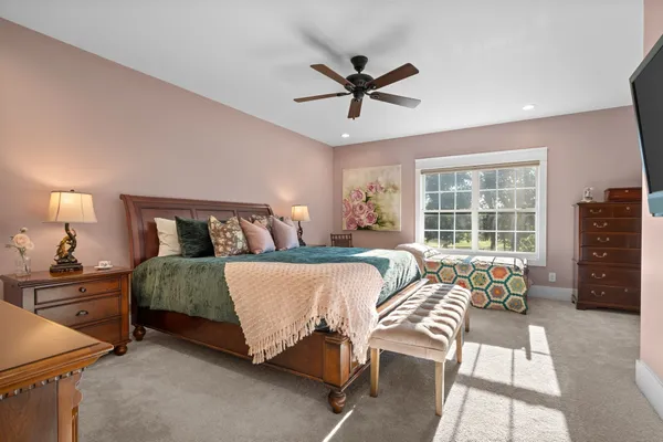 a bed sitting in a spacious bedroom next to a window