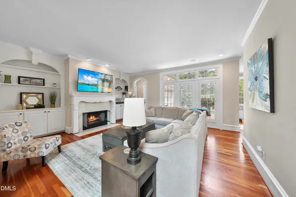 a kitchen with stainless steel appliances granite countertop a stove top oven a sink dishwasher a dining table and chairs with wooden floor