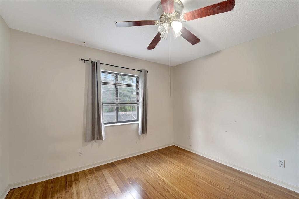 8040 Conservatory Circle Sarasota, FL 34243 - Photo 26 of 52 an empty room with wooden floor chandelier and windows