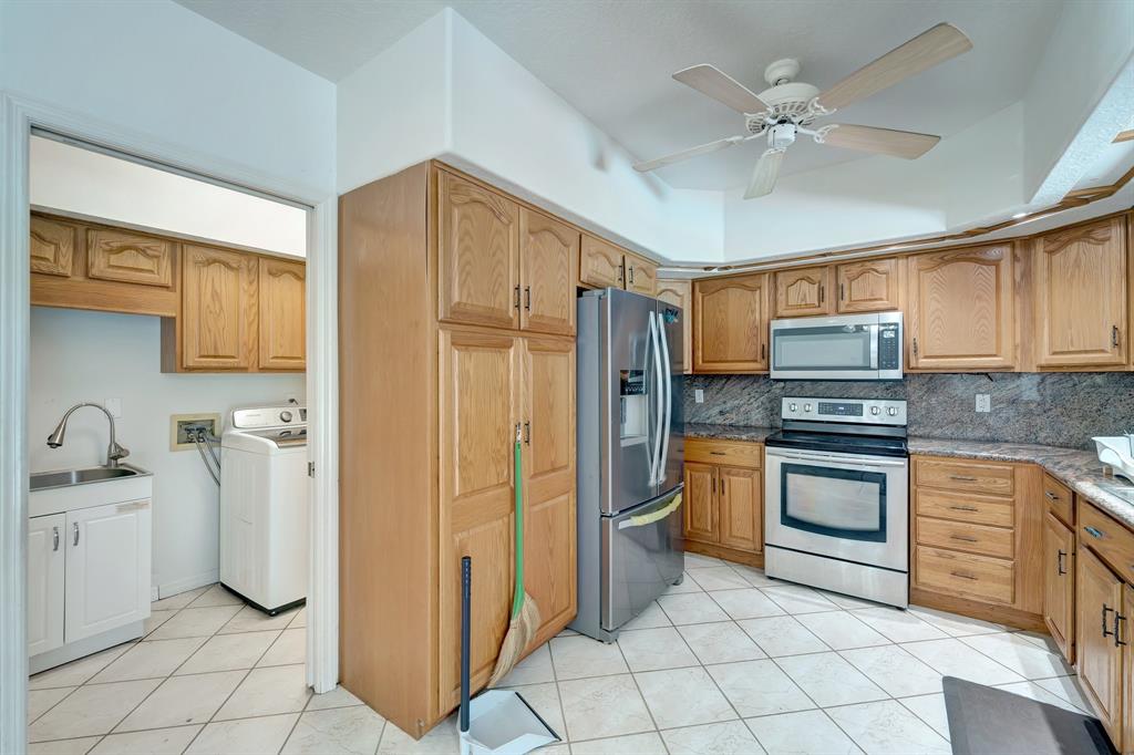 8040 Conservatory Circle Sarasota, FL 34243 - Photo 32 of 52 a kitchen with stainless steel appliances granite countertop a refrigerator and a sink
