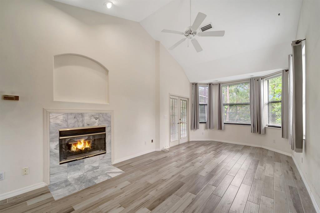 8040 Conservatory Circle Sarasota, FL 34243 - Photo 10 of 52 a view of an empty room with wooden floor fireplace and a window