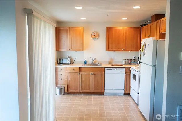 a kitchen with a refrigerator a sink and cabinets