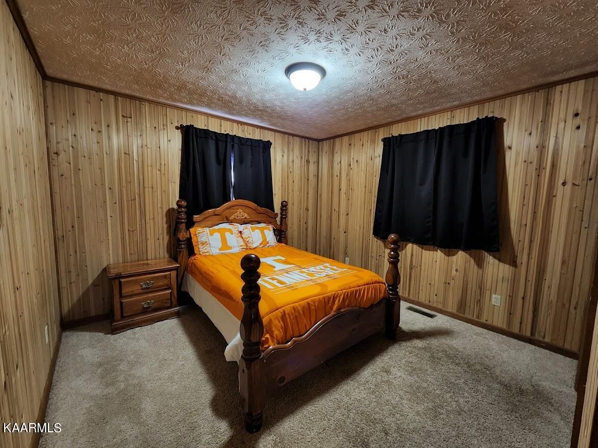 3390 Rocky Ridge Road Cosby, TN 37722 - Photo 13 of 45 a bed sitting in a spacious bedroom next to a window and a cabinet