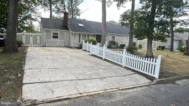 a view of a house with a fence and a tree