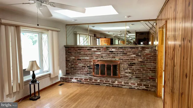 a living room with fireplace furniture and a ceiling fan