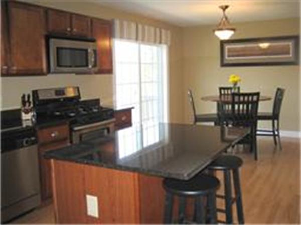 72 Snake Hill Road Ayer, MA 01432 - Photo 5 of 23 a kitchen with stainless steel appliances granite countertop a stove a microwave a sink a dining table and chairs