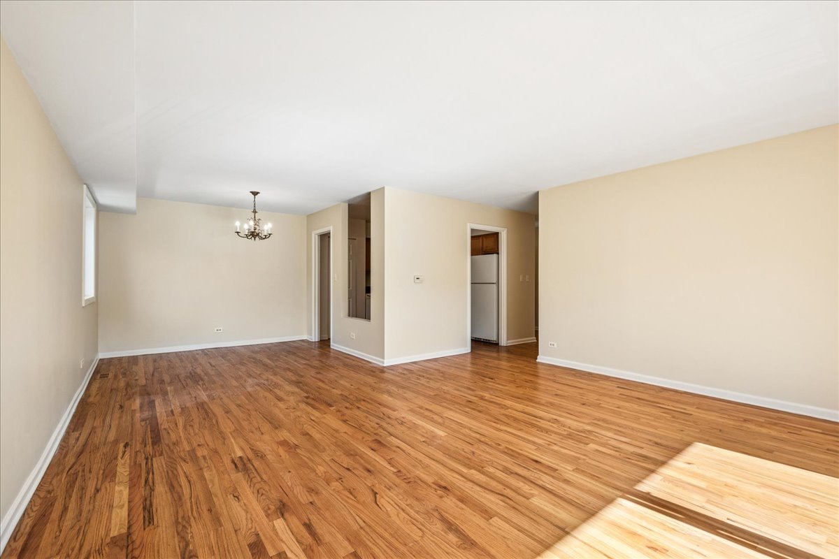 828 Oakton Street, Unit 3F Evanston, IL 60202 - Photo 6 of 21 a view of an empty room with wooden floor and a window
