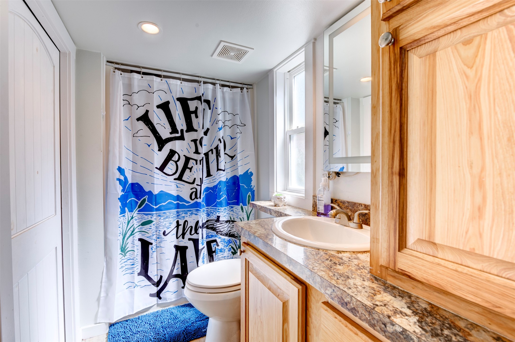664 Jensen Drive Cleveland, TX 77327 - Photo 22 of 36 a bathroom with a granite countertop sink a toilet and a shower curtain
