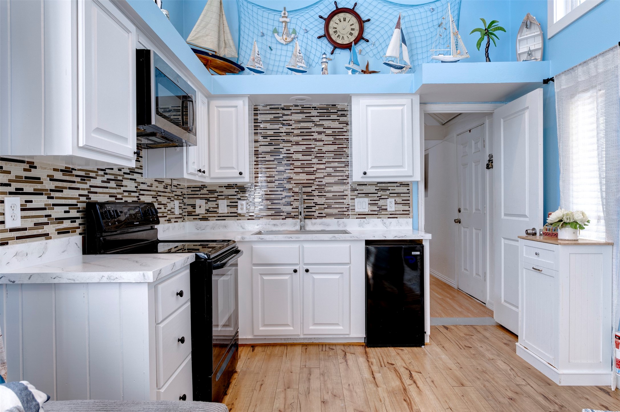 664 Jensen Drive Cleveland, TX 77327 - Photo 9 of 36 a kitchen with granite countertop a stove a microwave a sink and cabinets